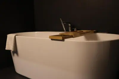 a white bath tub with a sink with a faucet at Klimieckiego 8A BW Apartments in Kraków