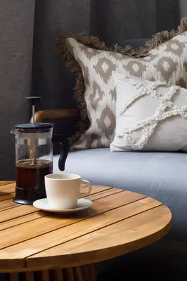 a cup of coffee on a wooden table next to a bed at Travelers Haven Spacious 70m2 2 Bedrooms Balcony Old Town Area in Kraków