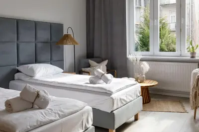 a bedroom with two beds and a window at Travelers Haven Spacious 70m2 2 Bedrooms Balcony Old Town Area in Kraków