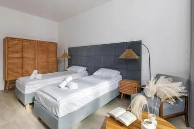 a bedroom with two beds and a table at Travelers Haven Spacious 70m2 2 Bedrooms Balcony Old Town Area in Kraków