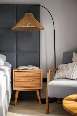 a nightstand with a lamp and a chair next to a bed at Travelers Haven Spacious 70m2 2 Bedrooms Balcony Old Town Area in Kraków