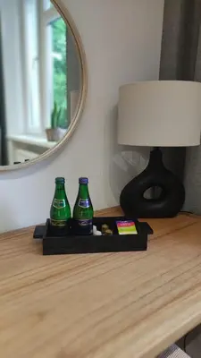 a table with two green bottles on a table with a mirror at Travelers Haven Spacious 70m2 2 Bedrooms Balcony Old Town Area in Kraków