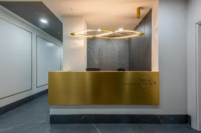 a lobby with a gold reception desk in a building at Aurum by MB Apartments in Kraków