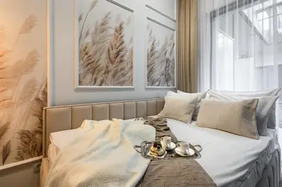 a bed with a tray of food on it at Aurum by MB Apartments in Kraków