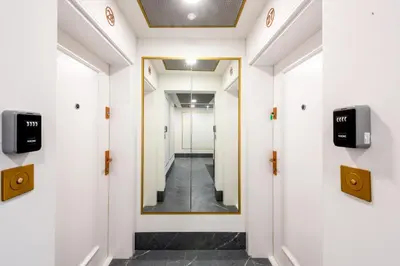 a hallway with white walls and a mirror on the wall at Aurum by MB Apartments in Kraków