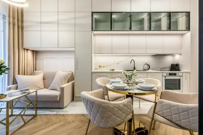 a kitchen and a living room with a table and chairs at Aurum by MB Apartments in Kraków