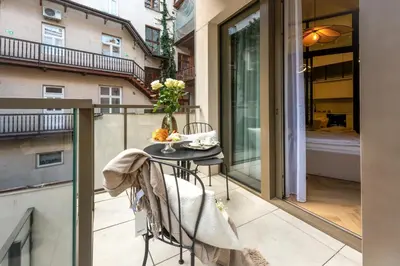 a small balcony with a table and a view of a building at Aurum by MB Apartments in Kraków