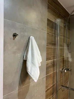 a shower with a towel hanging on a wall at Tomasza 25 Main Square Apartment in Kraków