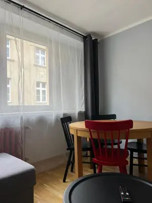 a room with a table and chairs and a window at Tomasza 25 Main Square Apartment in Kraków