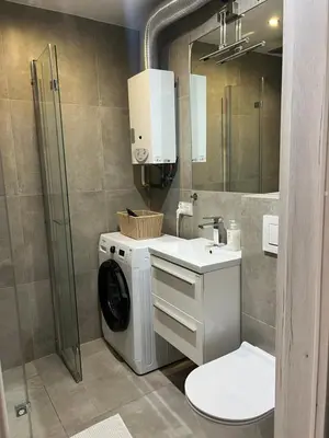 a bathroom with a washing machine and a washer at Tomasza 25 Main Square Apartment in Kraków