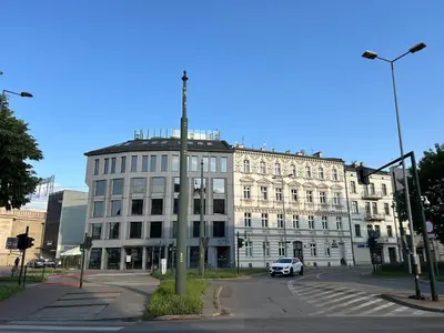 a large white building with a car parked in front of it at Sky Mirror jacuzzi in Kraków