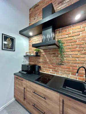 a kitchen with a brick wall and a stove at Sky Mirror jacuzzi in Kraków