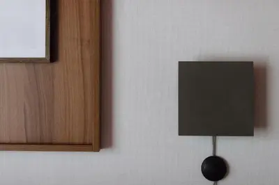 a lamp on a wall next to a door at Ironique by MB Apartments in Kraków