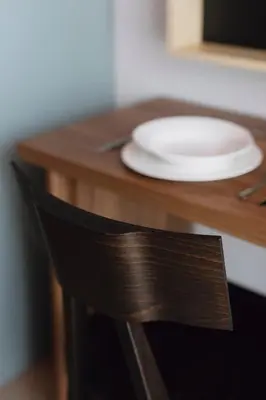 a plate sitting on a wooden table with a chair at Ironique by MB Apartments in Kraków