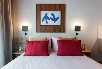 a bedroom with a bed with two red pillows at Ironique by MB Apartments in Kraków