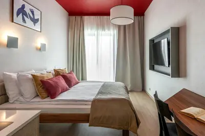 a hotel room with a bed and a tv at Ironique by MB Apartments in Kraków