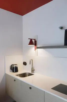 a white kitchen with a sink and a lamp at Ironique by MB Apartments in Kraków