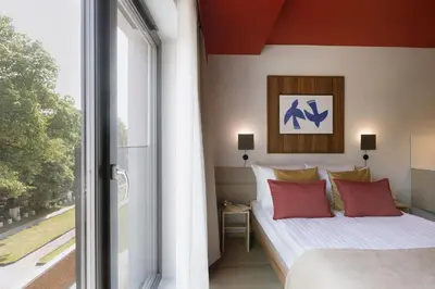 a bedroom with a bed and a large window at Ironique by MB Apartments in Kraków