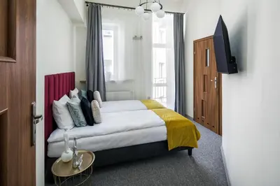 a hotel room with a bed and a tv at The Royal Patch Aparthotel in Kraków
