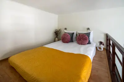 a bedroom with a bed with two pillows on it at The Royal Patch Aparthotel in Kraków