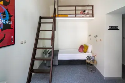 a room with a bunk bed and a ladder at The Royal Patch Aparthotel in Kraków