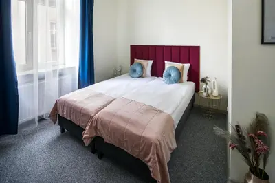 a bedroom with a large bed with blue pillows at The Royal Patch Aparthotel in Kraków