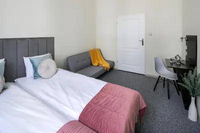 a bedroom with a large bed and a couch at The Royal Patch Aparthotel in Kraków