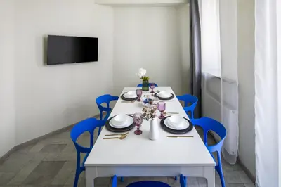 a white table with blue chairs in a room at The Royal Patch Aparthotel in Kraków