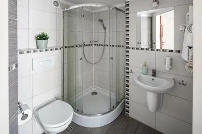 a bathroom with a shower and a toilet and a sink at The Royal Patch Aparthotel in Kraków