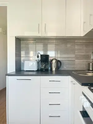 a kitchen with white cabinets and a coffee maker on the counter at Apartment with private kitchen in the heart of Krakow, City Center in Kraków