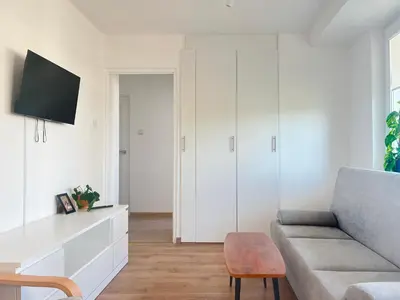 a living room with a couch and a tv at Apartment with private kitchen in the heart of Krakow, City Center in Kraków