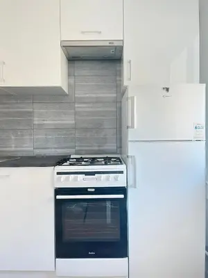 a white kitchen with a stove and a refrigerator at Apartment with private kitchen in the heart of Krakow, City Center in Kraków