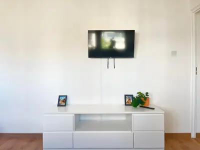 a white dresser with a tv on the wall at Apartment with private kitchen in the heart of Krakow, City Center in Kraków