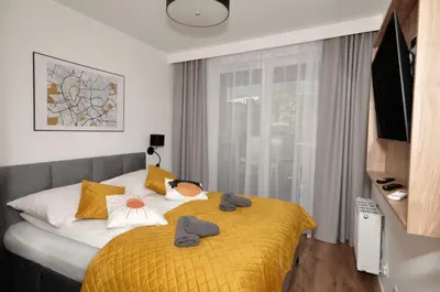 a bedroom with a bed with a yellow blanket at Myśliwska Solar Garden Premium Apartment Wawelofts - free Garage in Kraków