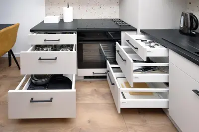 a kitchen with white cabinets and a black counter top at Myśliwska Solar Garden Premium Apartment Wawelofts - free Garage in Kraków
