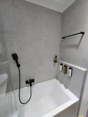 a bathroom with a shower with a bath tub at Myśliwska Solar Garden Premium Apartment Wawelofts - free Garage in Kraków