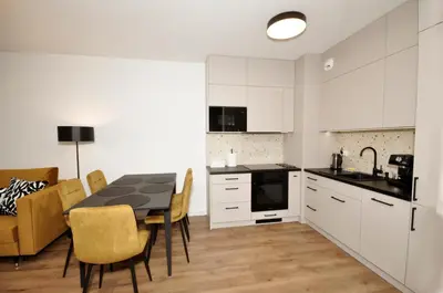 a kitchen and dining room with a table and chairs at Myśliwska Solar Garden Premium Apartment Wawelofts - free Garage in Kraków