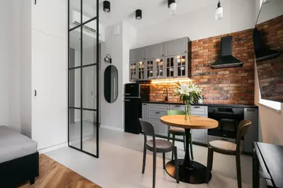 a kitchen with a table and chairs in a room at Native Apartments Długa 24I3 in Kraków