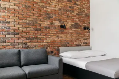 a room with two beds and a brick wall at Native Apartments Długa 24I3 in Kraków