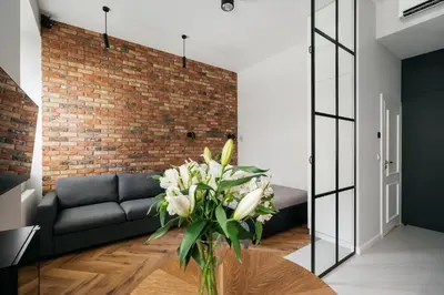 a living room with a couch and a table with a vase of flowers at Native Apartments Długa 24I3 in Kraków