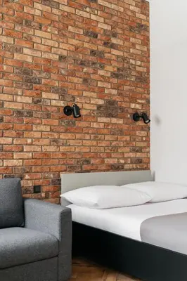 a bedroom with two beds and a brick wall at Native Apartments Długa 24I3 in Kraków