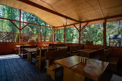 an empty restaurant with wooden tables and wooden chairs at Kemping i Pole Namiotowe River Park Zator SPA RESORT in Zator