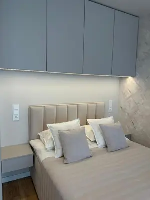 a large bed with white pillows on top of it at Kaskada Apartment in Kraków