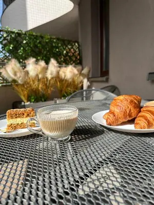 a table with two plates of croissants and a cup of coffee at Kaskada Apartment in Kraków