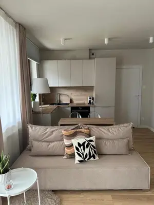 a living room with a couch and a kitchen at Kaskada Apartment in Kraków