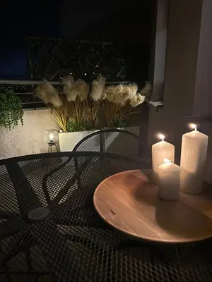 a table with two white candles on a patio at Kaskada Apartment in Kraków