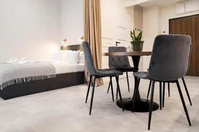 a bedroom with a bed and a table and chairs at Househost Apartment Smoleńsk Elegant Studio AC Lift Security in Kraków