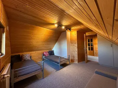 a room with two benches and a wooden ceiling at Gorczańska Chata Lubomierz in Lubomierz