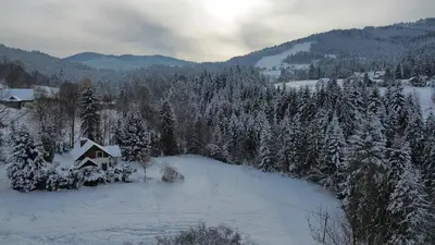 a house is covered in snow on a mountain at Gorczańska Chata Lubomierz in Lubomierz