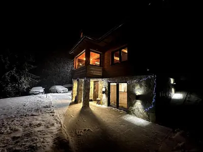a house in the snow at night at Gorczańska Chata Lubomierz in Lubomierz